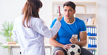Arzt untersucht Fußballspieler