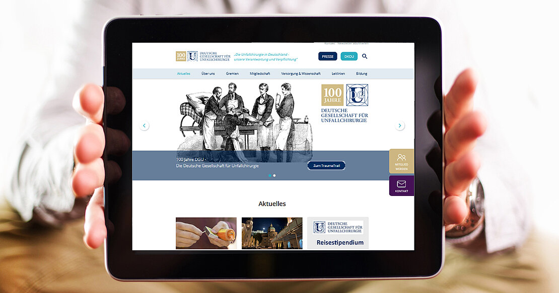 Arzt hält Tablet-Computer mit der neuen DGU-Website
