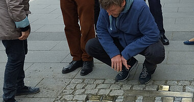 DGU verlegt Stolpersteine Mai 2023 © J. Arndt / DGU Mann begutachtet eingelassene Stolpersteine