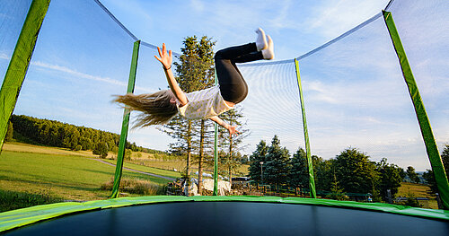 Mädchen macht waghalsige Sprünge auf Trampolin