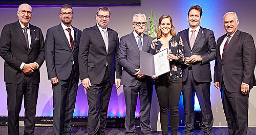 Preisträgerin Franziska Schwarck nimmt Urkunde auf dem Podium entgegen