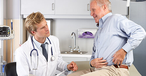 Arzt untersucht älteren Patienten mit Hüftschmerzen